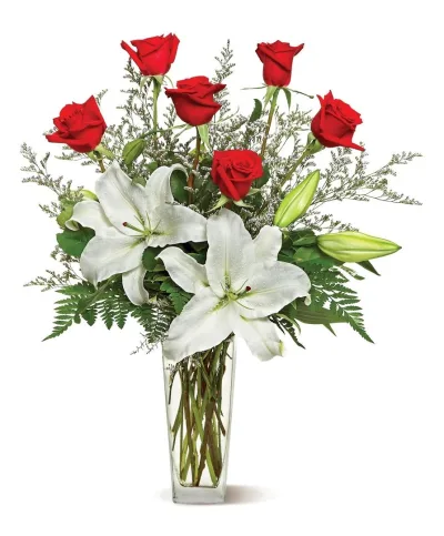 Rosas rojas y lilium blanco con statice y helecho en jarrón de cristal